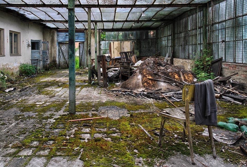 Skleněnou střechou dopadá světlo na betonové dlaždice i relikty někdejšího učebního ruchu.