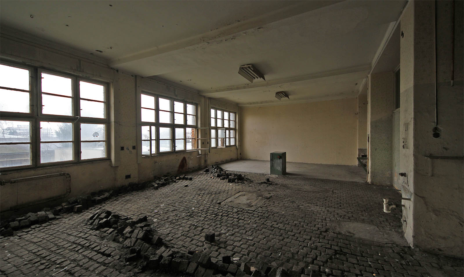 Všechny vnitřní prostory elektrárny jsou vyklizené a prázdné, včetně dílen se špalíkovou dlažbou.