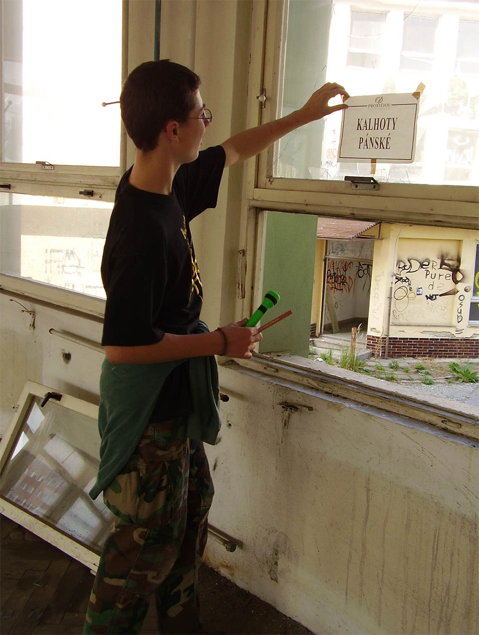 V poslední fázi svého života sloužila textilka Kras také jako místo konání výprodejů z kolabujících českých oděvních podniků. Kolega na snímku odlepuje cedulku s logem <a href="/Tema/Oděvní průmysl Prostějov">OP Prostějov</a>.