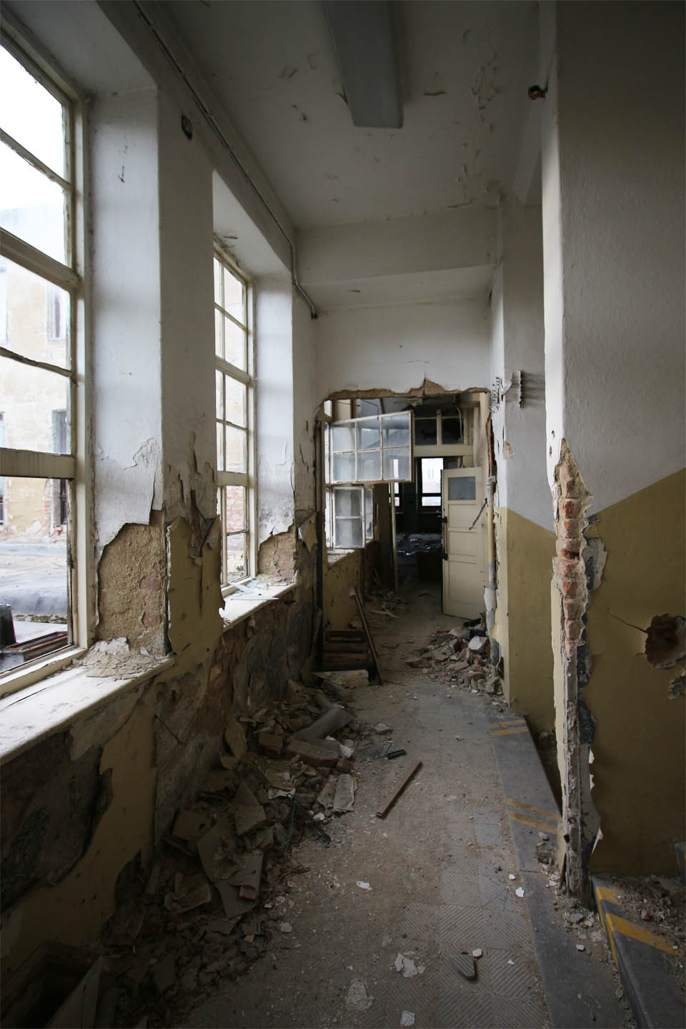 Otevřenými okny profukuje chladný vítr stejně jako těmi rozbitými. Tady už není, co zachraňovat.