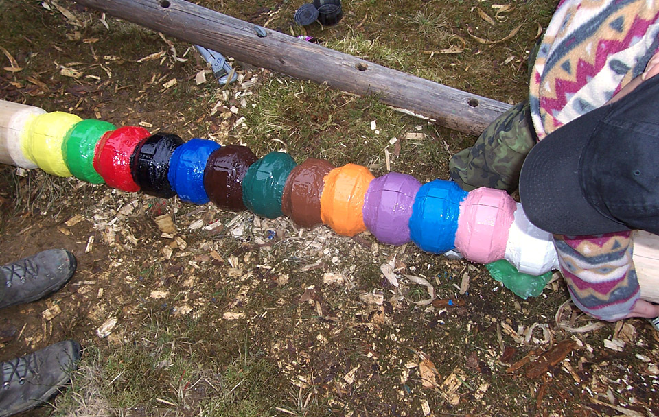 Třináct barevných knoflíků symbolizuje třináct bobříků z knihy Hoši od Bobří řeky. Nejníže je žlutý bobřík mrštnosti, nejvýše pak náročný bílý bobřík ušlechtilosti.