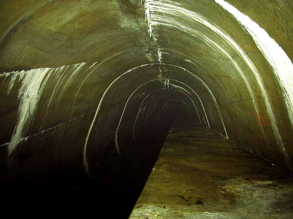 Výška nadloží rychle stoupá. Brzy se štola ocitá ve značné hloubce a sloupec vody tlačící na betonovou klenbu roste. Prasklinkami prochází voda pod velkým tlakem, rozprašuje se na jemnou mlhu nebo stéká po stěnách a vytváří sintrové krajky.