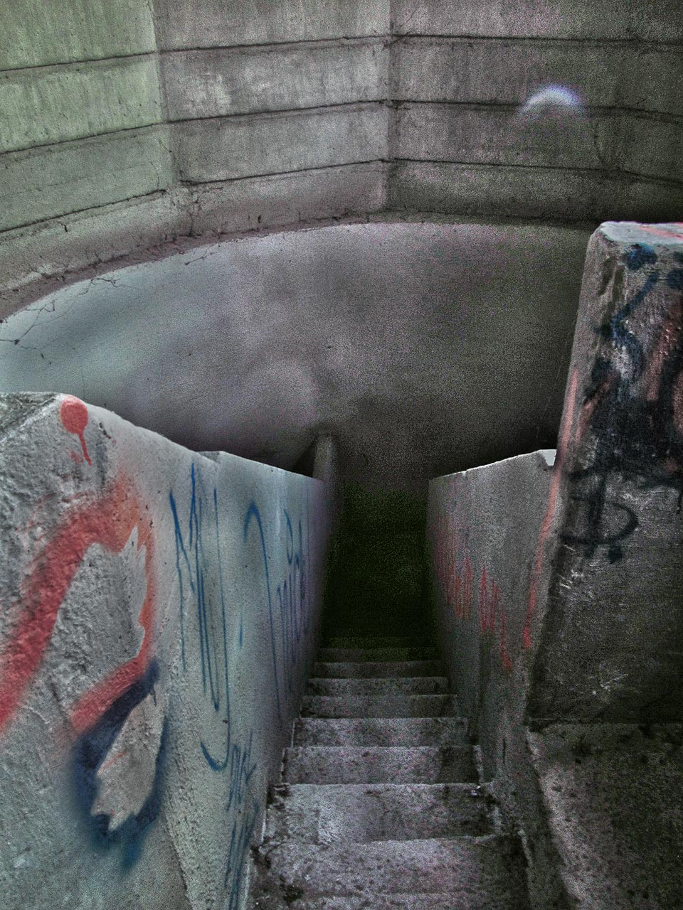 Poslední díl schodiště a ocitáme se v n-úhelníkové stavbě. Zvenku nenápadná betonová rotunda ukrývá vstup do jiného světa.