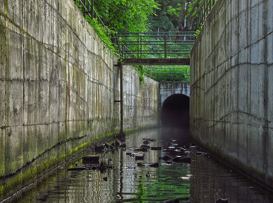 Temný chřtán tunelu vedoucího do neznáma, ze kterého vytéká na povrch kalná voda a mlha. To je tunel Ponávky.