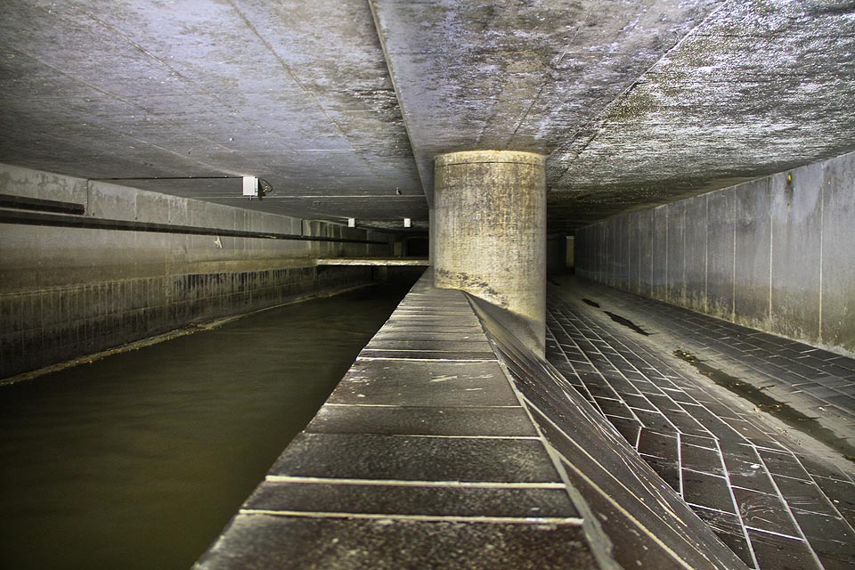 Pohled po proudu (k jihu) na přelivnou hranu a stoku. Vlevo je dobře vidět snížená část stoky, za kterou spadají splašky za hromového hukotu do kmenové stoky C pod Křenovou ulici.