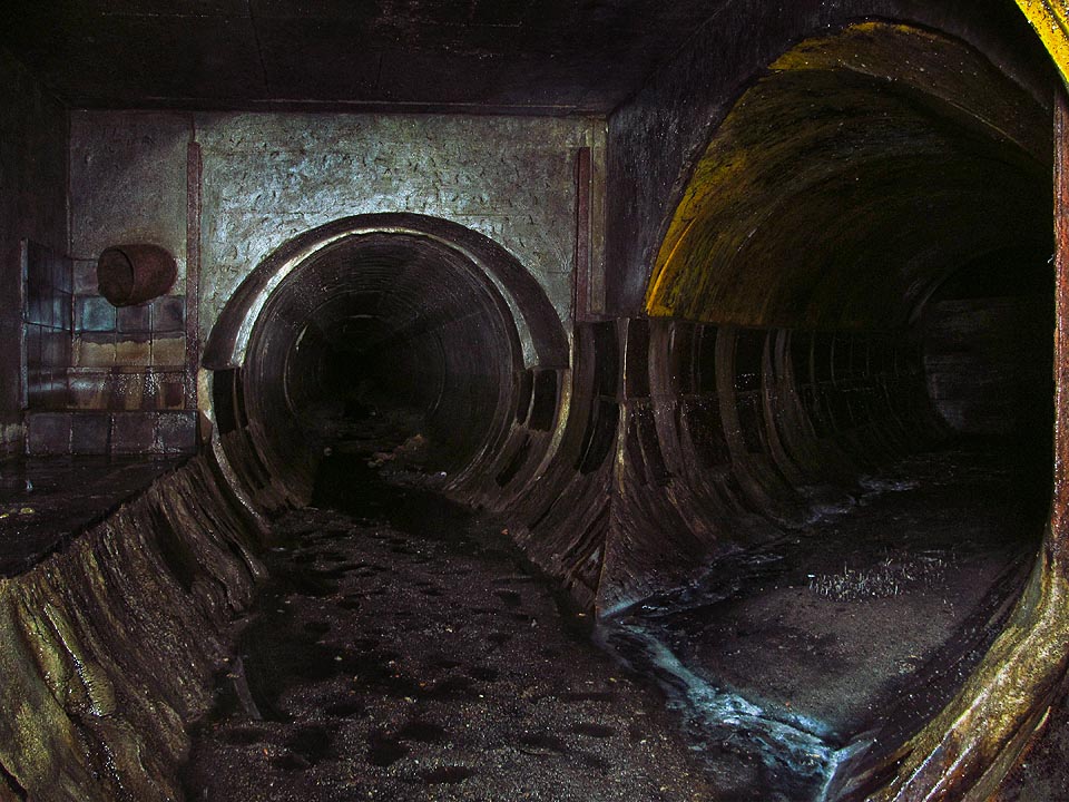 Ani zde nechybí propojení s kmenovou stokou C. Dno je pokryto vysokou vrstvou nánosů a kanálem probíhá nemálo potkanů.