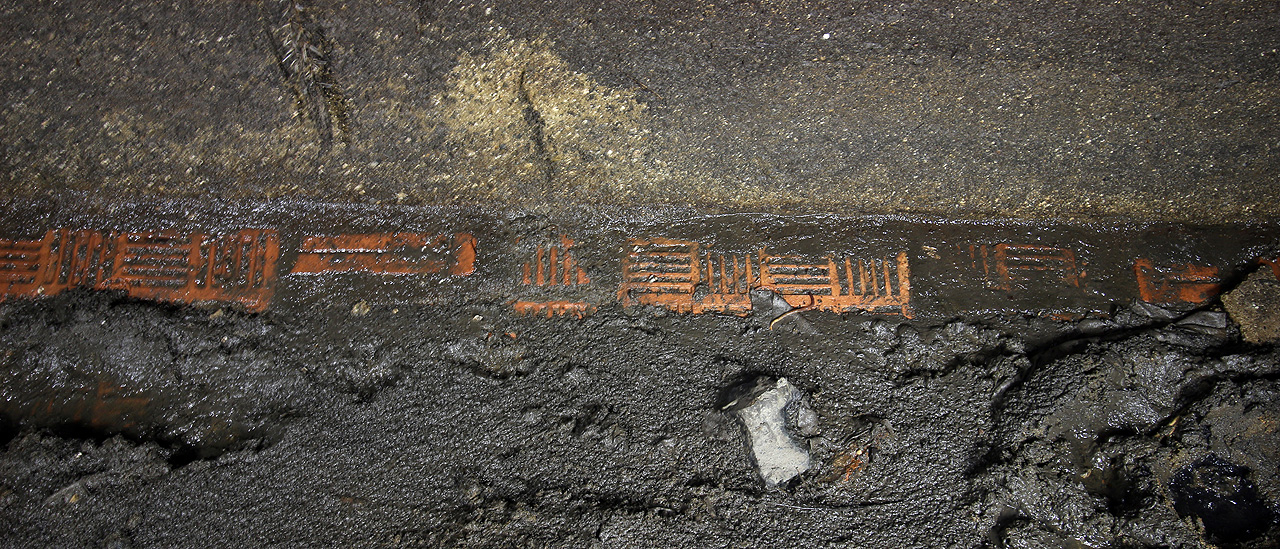 Místy je bahno přece jen částečně smyto a na povrch vystupují keramické dlaždice, které měly být vůči proudící vodě odolnější než prvorepublikový beton.