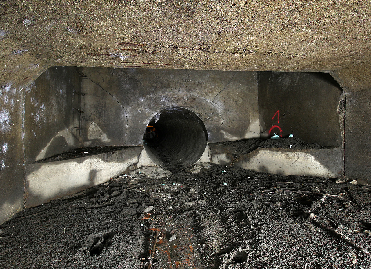 Napojení chodby obdélníkového profilu z 2. období zakanalizování (1932) na kruhovou rouru o průměru 120 cm ze 3. období výstavby (1950–1953).