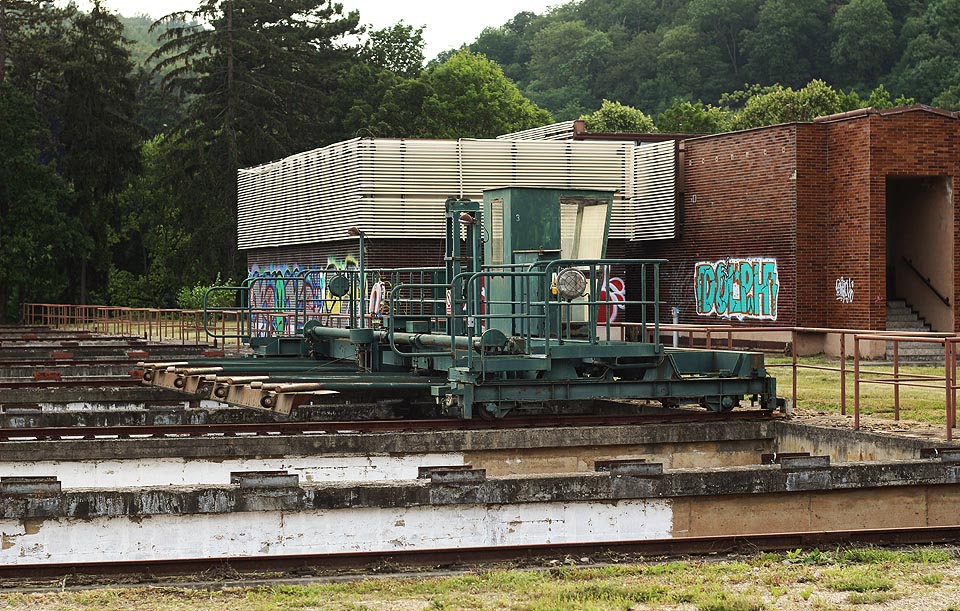 Pojízdný shrabovací jeřáb mohl shrabovat usazený kal ze dna nádrží, nad kterými dovedl přejíždět v obou směrech, do kalových jímek. Po naředění byl vypouštěn z vodárny rovnou do kanalizace. V pozadí <a href="/Tema/Budova homogenizace v Pisárkách">budova homogenizace a agregace</a>.