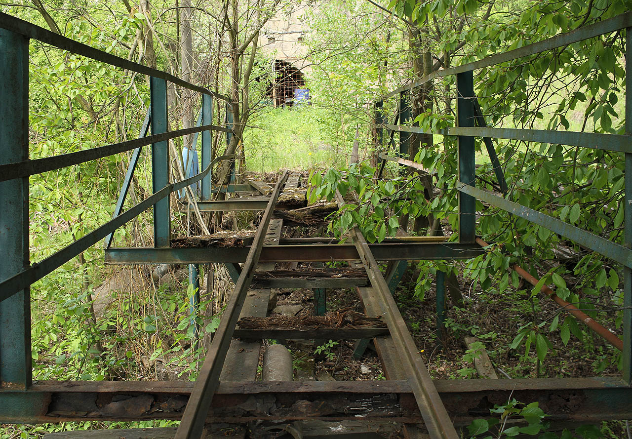 V opačném směru se takřka přímo naproti rampě šklebí na „cestující“ temné ústí betonového tunelu.