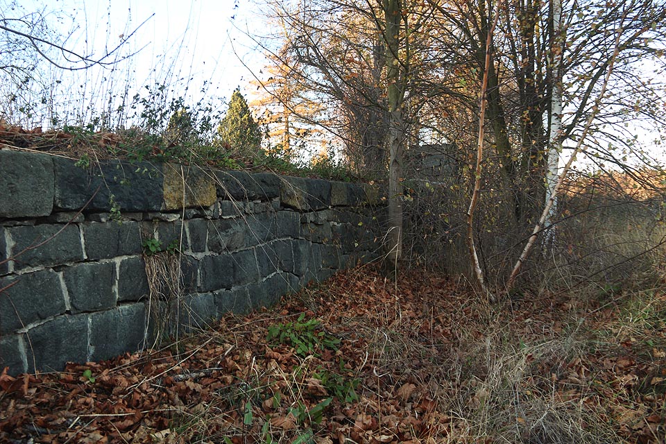 Vlečka byla zřejmě tvořená jedinou kolejí podél bytelné kamenné rampy se dvěma výškovými úrovněmi. Vlevo na snímku je úroveň nižší, odpovídající přibližně výšce plošinového vozu.