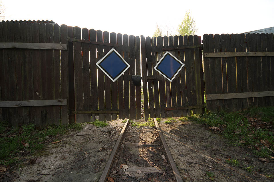 Z areálu vychází úzká kolej přímo ke <a href="/Tema/Nový Drahov (žst)">staniční budově</a> prostými vrátky.