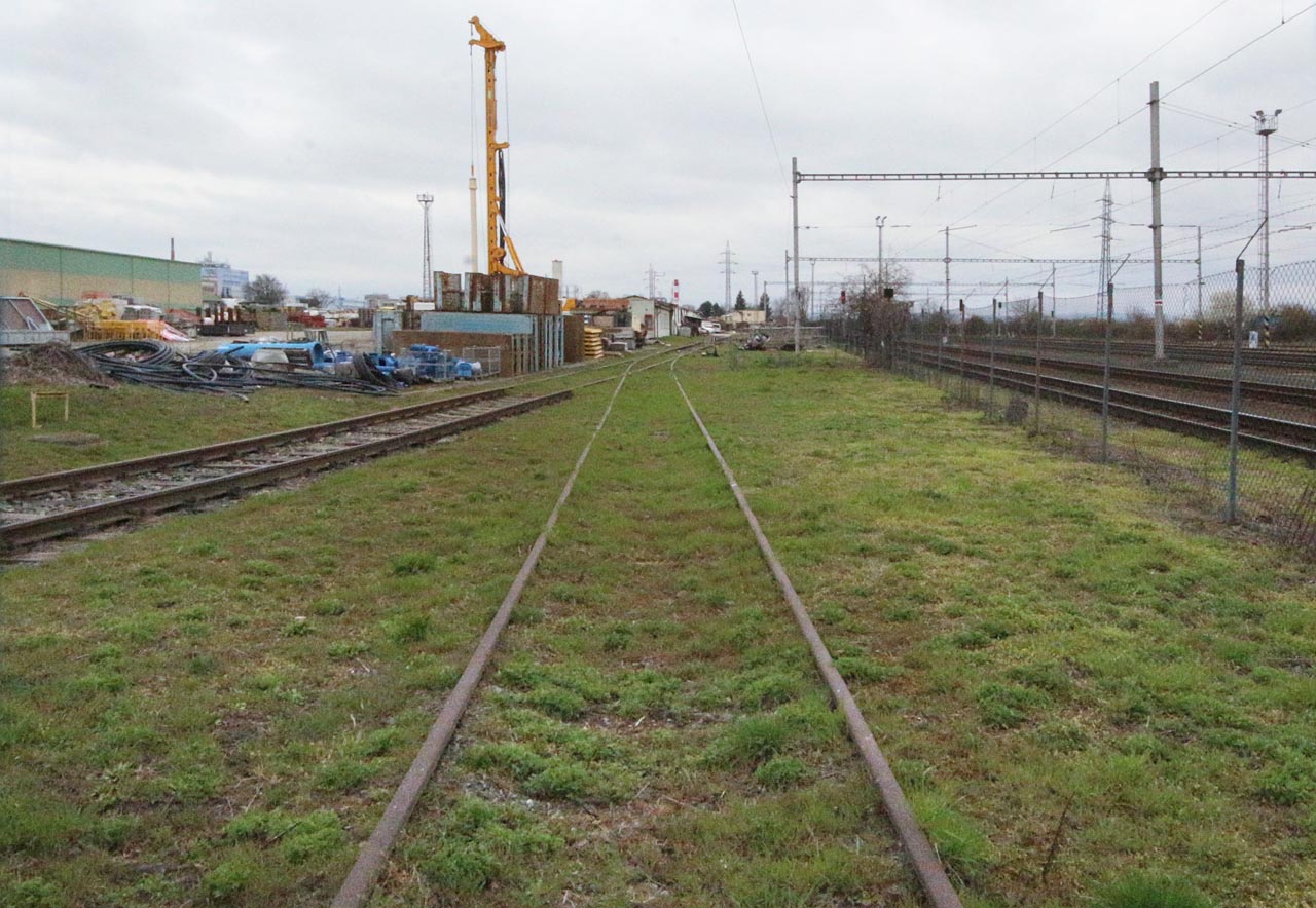 Protisměrný pohled k severu na <a href="/Tema/Vlečka Modřice - FIRESTA Modřice">současnou vlečku Firesty</a>. V dálce jsou vidět baráky stojící od války na rampě překladiště mezi vlečkou a úzkokolejnou drahou.