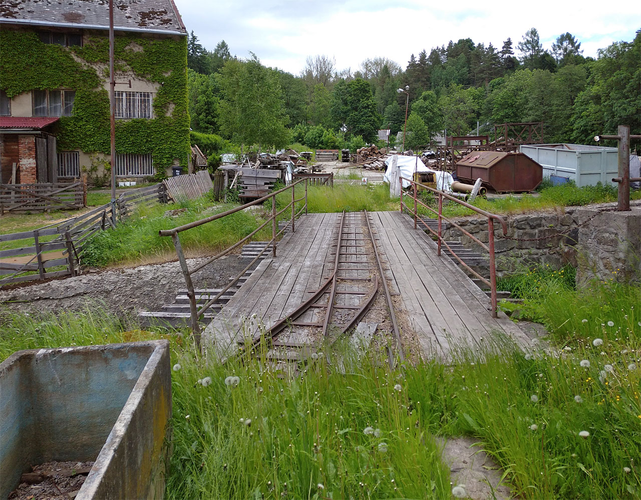 Pohled od budovy katru na sever za most přes Březnou, kde se stále nachází rozsáhlá skládka. Nyní nejen dřeva.