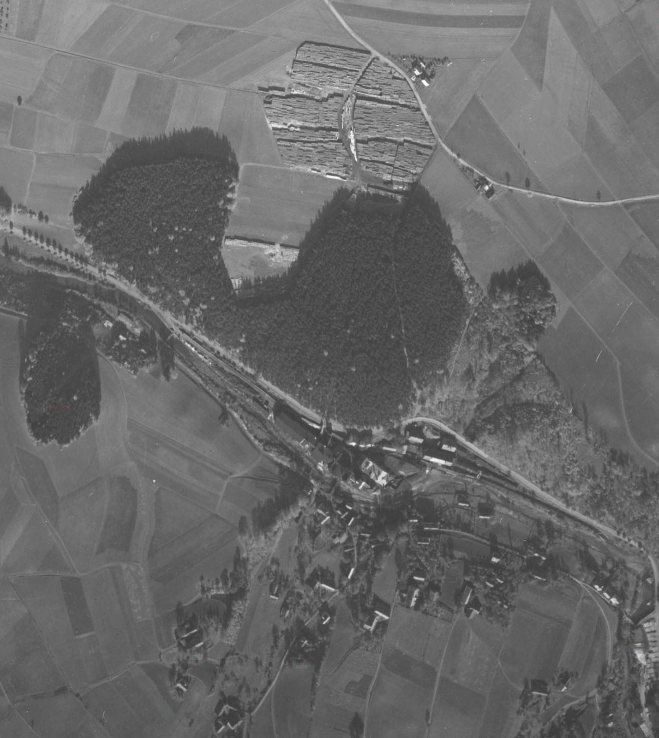 Na samotném snímku je dobře patrná trasa úzkokolejky a zejména most svážnice přes silnici z Písečné do Mikulovic v severozápadním cípu papírny.