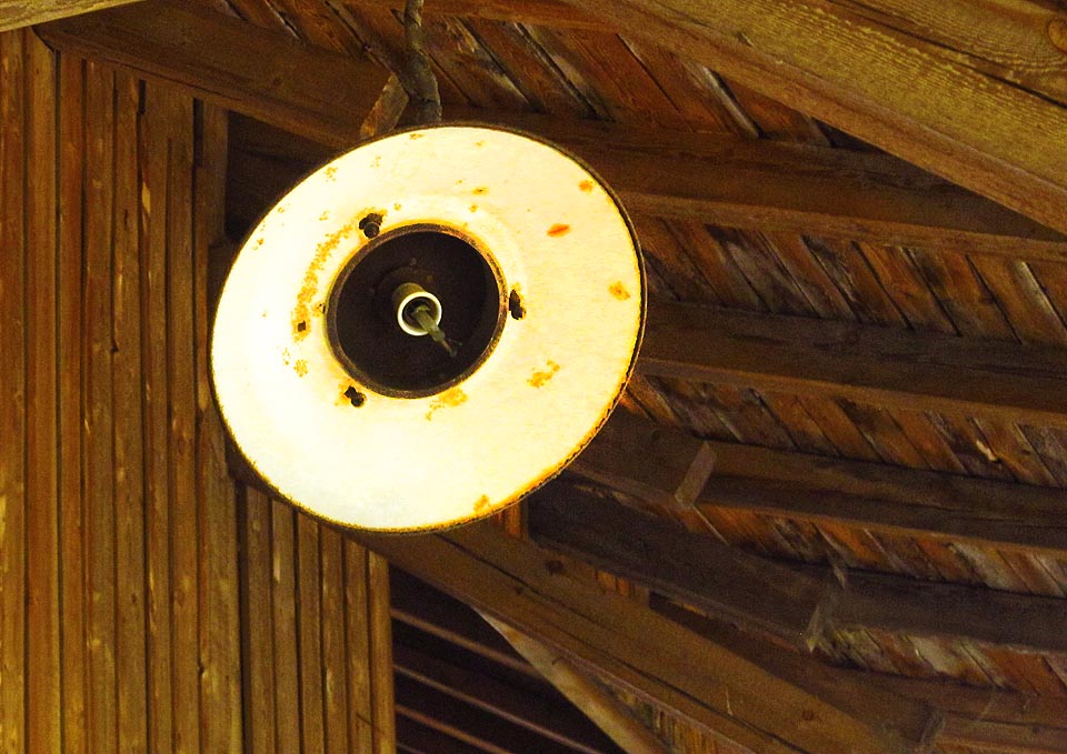 Oslepená lampa marně zírá na uhynulou továrnu.