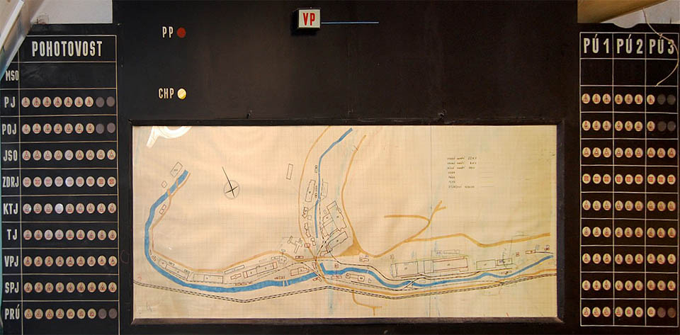 Plán východní části <a href="/Tema/Adamov">Adamova</a> na velitelském stanovišti je cenný hned z několika důvodů. Zobrazuje město zhruba na konci 70. let 20. století, kdy továrna dosáhla svého největšího rozmachu a zachycuje současně starou i novou podobu <a href="/Tema/Vlečka Adamov - strojírny">vlečkové sítě</a> strojíren. Po krátkou dobu několika let skutečně vedly v <a href="/Tema/Adamov">Adamově</a> koleje skoro všude.