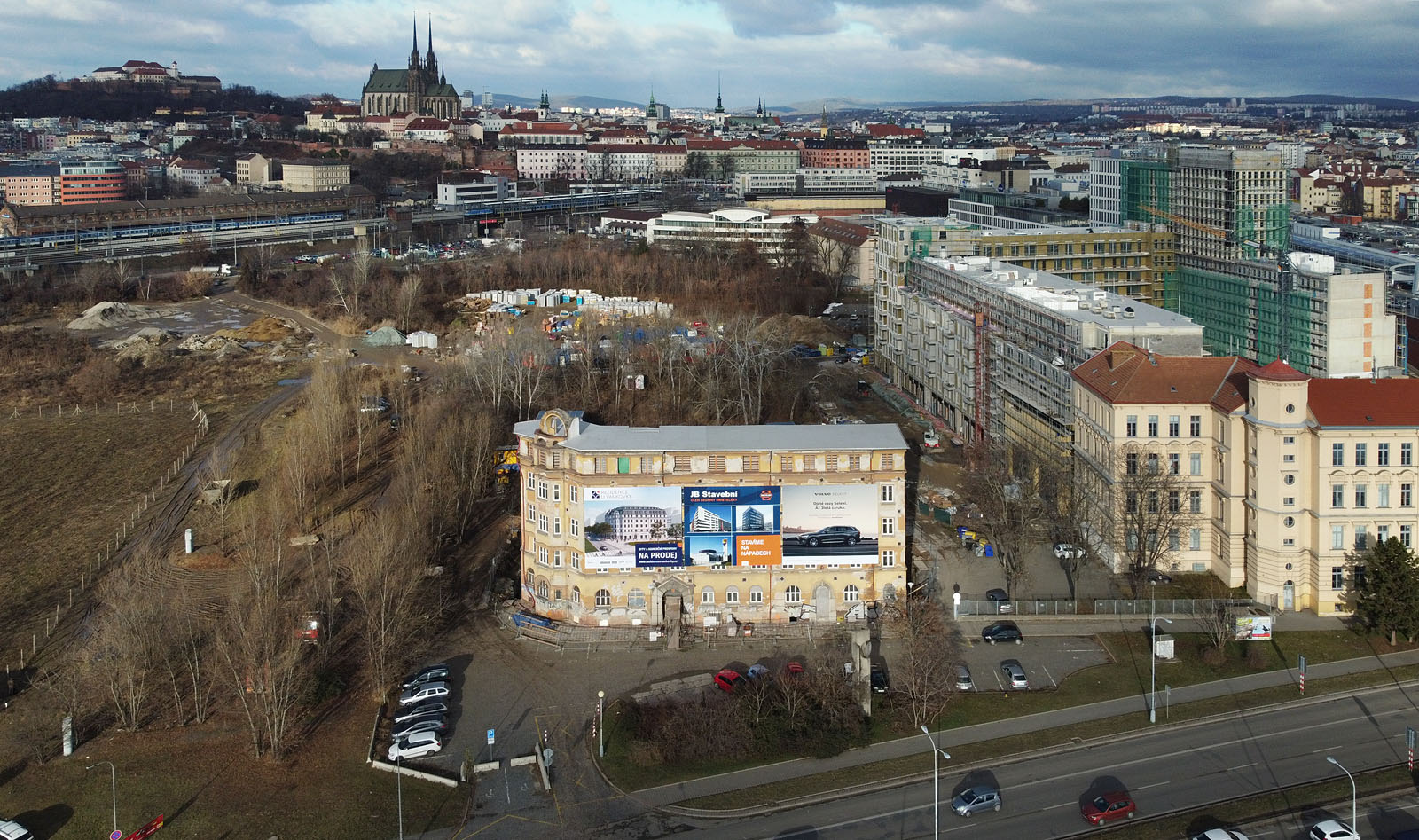 Letecký pohled na dům Opuštěná 4 na sklonku roku 2021. Původní sedlová střecha zmizela, nahrazena provizorní konstrukcí, která chrání rekonstruovaný dům před deštěm. Vpravo od domu se rýsuje potenciální nová městská ulice, jež byla plánovaná již v roce 1910 a pak se na ni na více než 100 let zapomnělo.