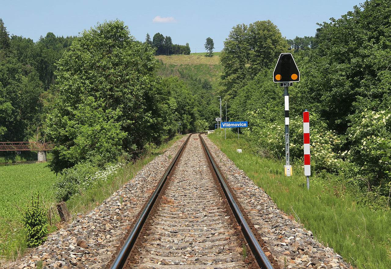 Pohled na zastávku Vilémovice ve směru od <a href="/Tema/Světlá nad Sázavou (žst)">Světlé nad Sázavou</a>. Ačkoliv byl v roce 2021 instalován nový přejezdník, na přejezdu samotném stále platí rychlost 20 km/h.