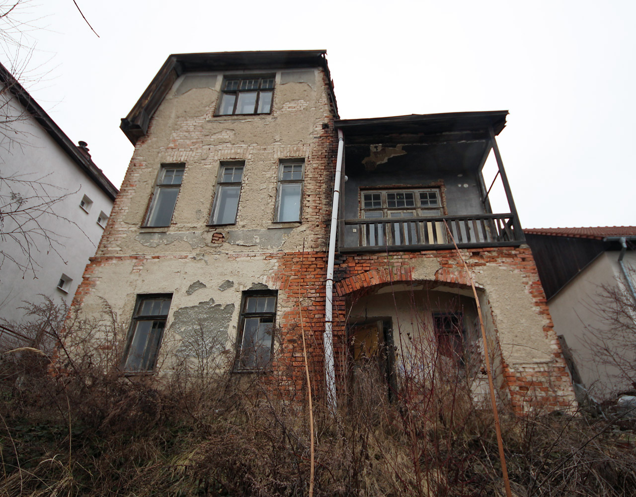 Pohled ze zahrady a otevřené dveře, které naznačují, že dny vilky jsou pravděpodobně již sečteny.