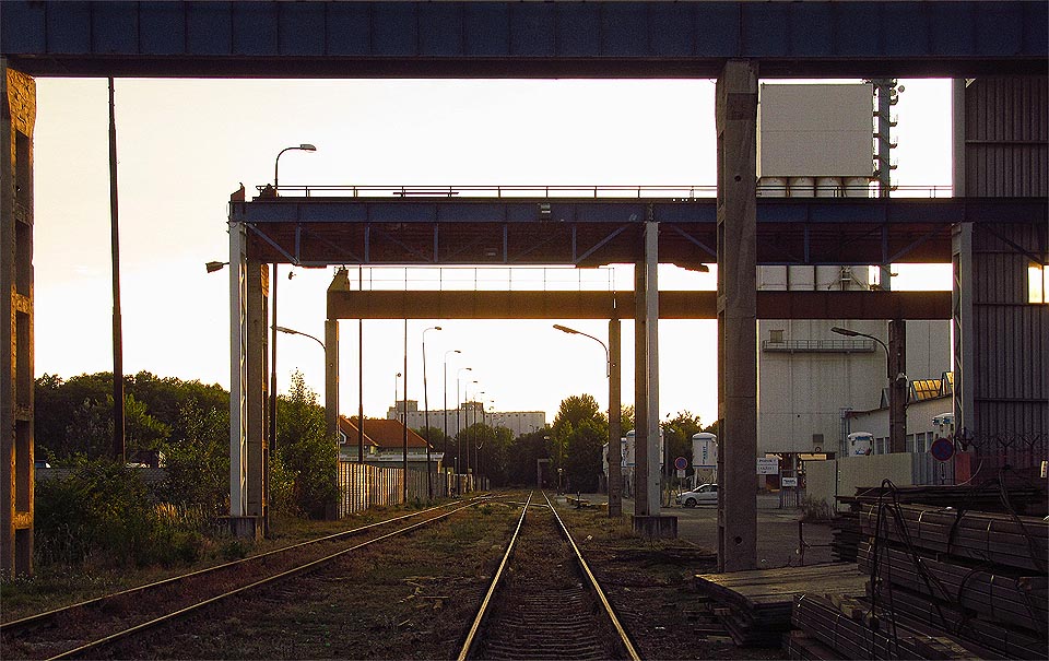 Kolejiště končí pod masivní konstrukcí mostových jeřábů společnosti Raven CZ.