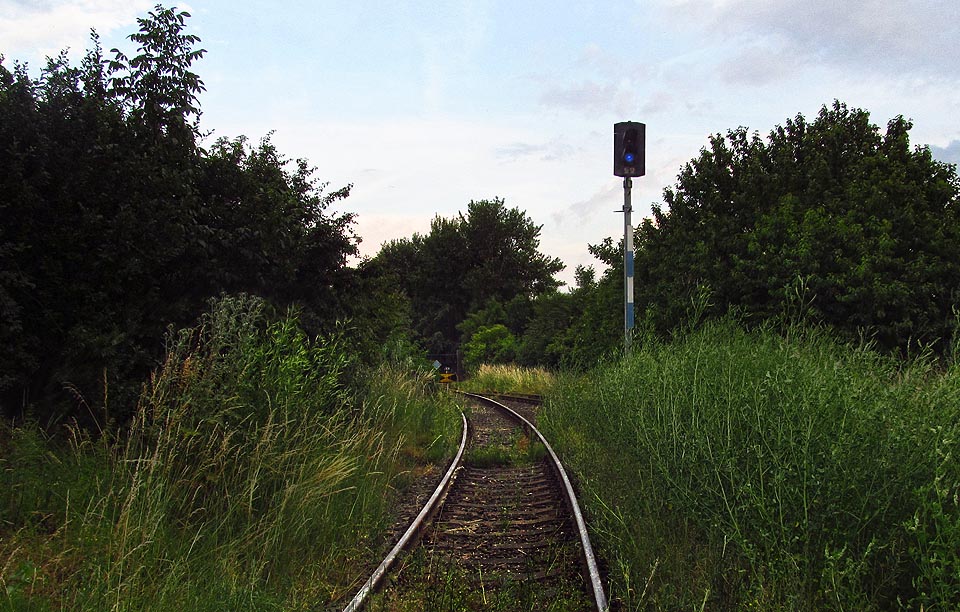Za seřaďvoacím návěstidlem je dobře vidět brána areálu sila i odvratná kolej.