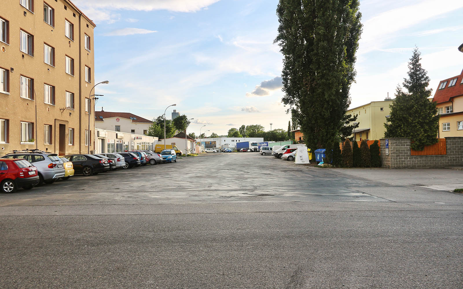 Pohled na ulici U Vlečky od východu, směrem zpět ke stanici. Vlečka vedla v pravé části ulice, přibližně na místě bílého kontejneru, dnes její trasu kryje  vrstva všudypřítomného asfaltu.