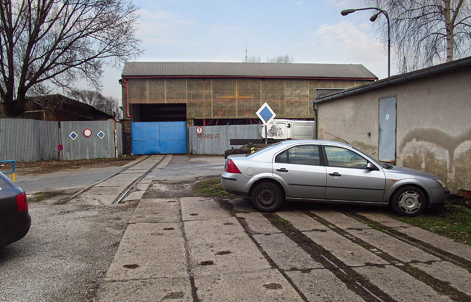 Místo bývalé výhybky E3 před přejezdem s ulicí Vodařskou a dvojice vrat, do kterých vlečka dříve pokračovala.