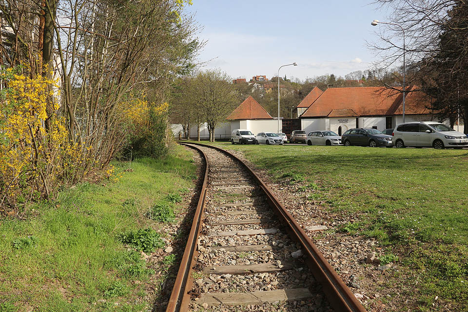 Po krátkém úseku s klasickými kolejnicemi ve čtvrté části vlečky přechází před křížením s Křížkovského ulicí vlečka opět na žlábkové kolejnice. V dálce na stráni domečky <a href="/Tema/Kamenná čtvrť (ulice v Brně)">Kamenné kolonie</a>.