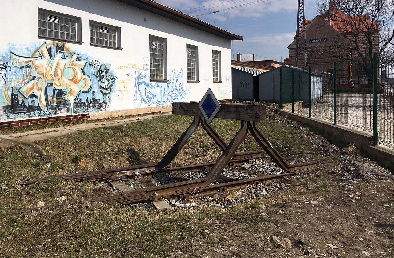 Zarážedlo na konci kusé koleje, která zbyla z vlečky, v roce 2018, tedy pět let po rekonstrukci přednádražního prostoru včetně ulice Krále Jiřího (za plotem vpravo).