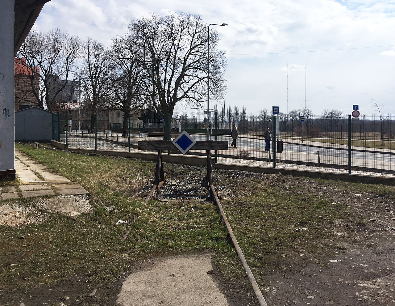 Při pohledu od západu je za nově rekonstruovaným terminálem integrované dopravy jasně patrná vjezdová brána do cukrovaru, na jehož místě ovšem zejem prázdná planina.