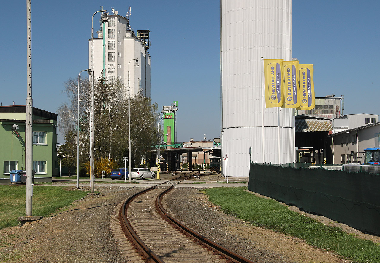 Za branou a přejezdem se kolej rozplétá na trojici rovnoběžných kusých kolejí procházejících nakládacím a vykládacím prostorem. Za branou a přejezdem se kolej rozplétá na trojici rovnoběžných kusých kolejí procházejících nakládacím a vykládacím prostorem.