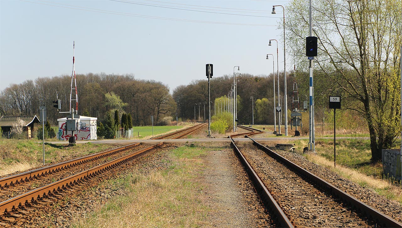 Díle směrem k východu překračuje vlečková kolej společně s tratí do Hulína ulici Jožky Silného, chráněnou závorami a dvojicí seřazovacích návěstidel Se S3 a Se S4.
