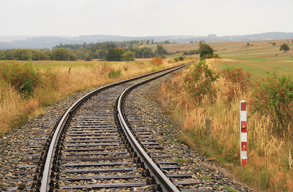 Od Okareckého potoka a bývalé zastávky Vícenice vlečka vytrvale stoupá mezi poli až do plochého sedla o výšce 455 m nad mořem.