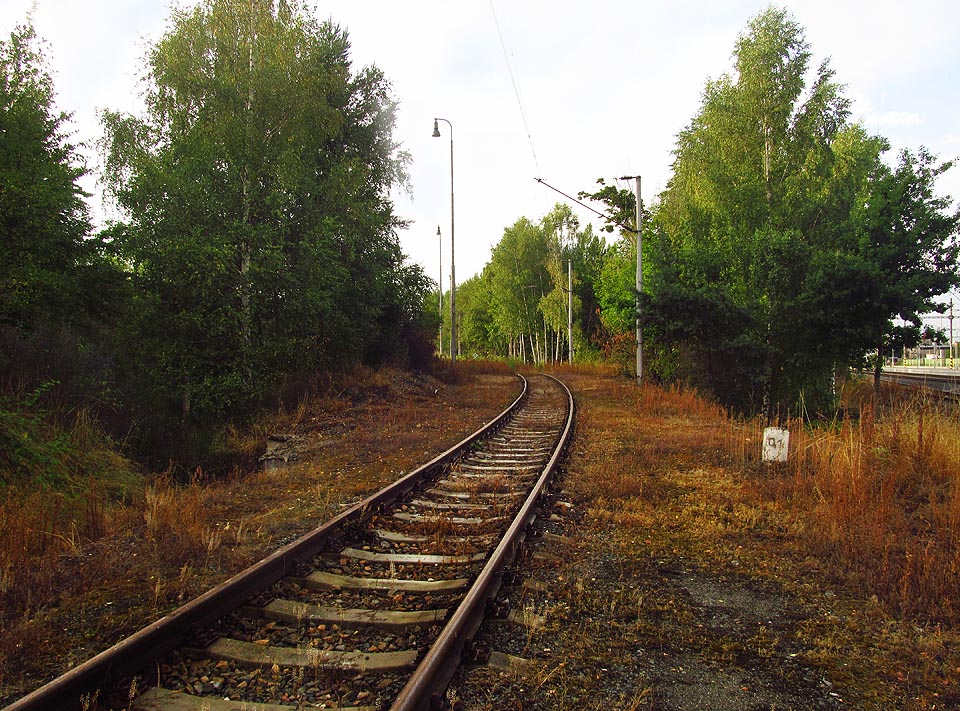 Od stanice vlečka mírně stoupá levotočivým obloukem k předávacímu kolejišti a manipulační ploše u skladu.
