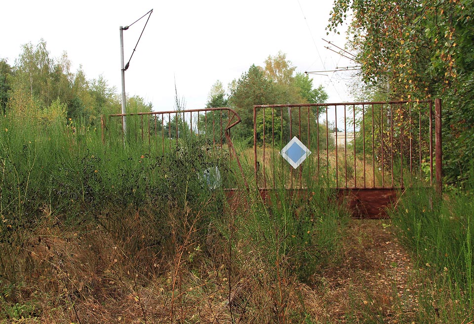 Přestože je brána zamčená, kdo chce, projde dále ke kolejisšti.