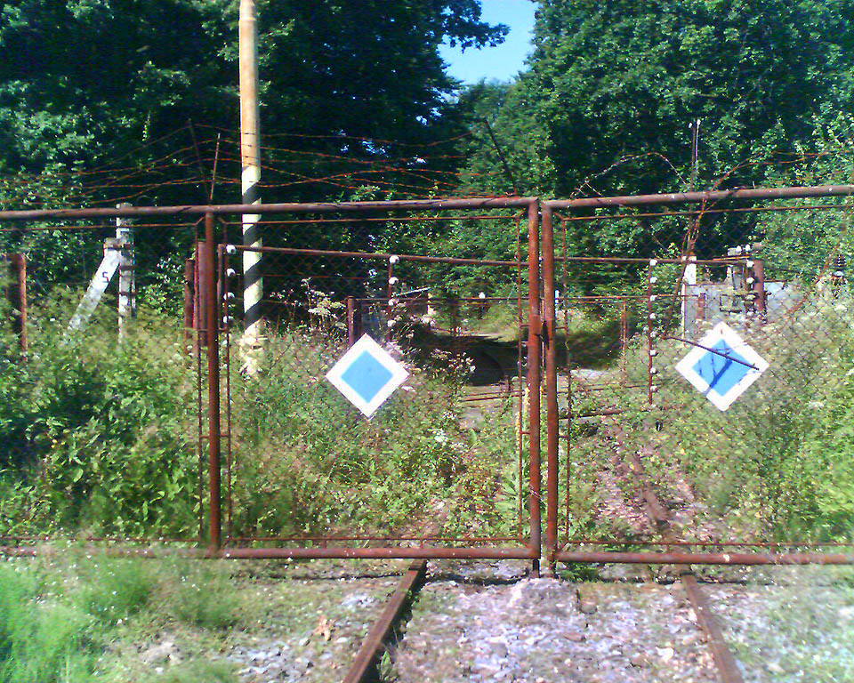 Na snímku z roku 2005 jsou dobře patrné tři brány - prostřední s vysokonapěťovým elektrickým ohradníkem a dvě ochranné z obou stran okolo ní. Zcela vzadu pak byla ještě jedna, plechová, neprůhledná brána.