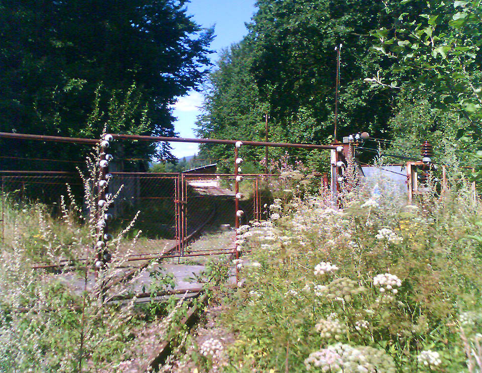 Kradmý pohled za bránu stále ještě střeženého areálu dává nahlédnout na první skladištní budovu ještě existujícího vlečkového nádraží.