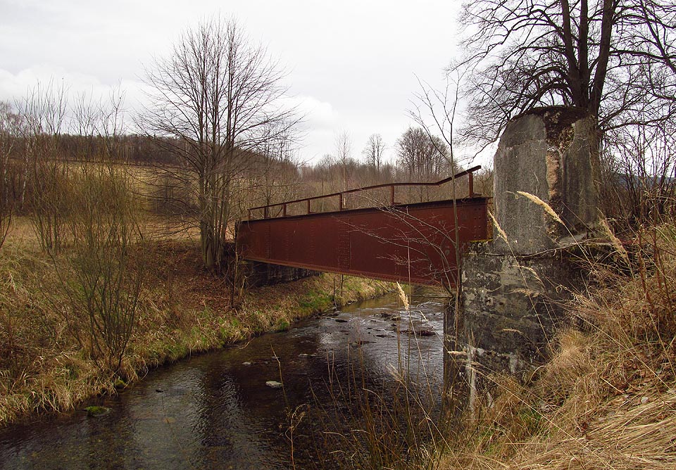 Od Quanaba víme, že betonový podstavec v popředí není původní, ale jde o zbytky tzv. „zvláštního zařízení“,  postaveného na podzim roku 1938 a sloužícího k zabarikádování mostu a znemožnění jeho využití německou armádou v očekávané válce s Československem.
