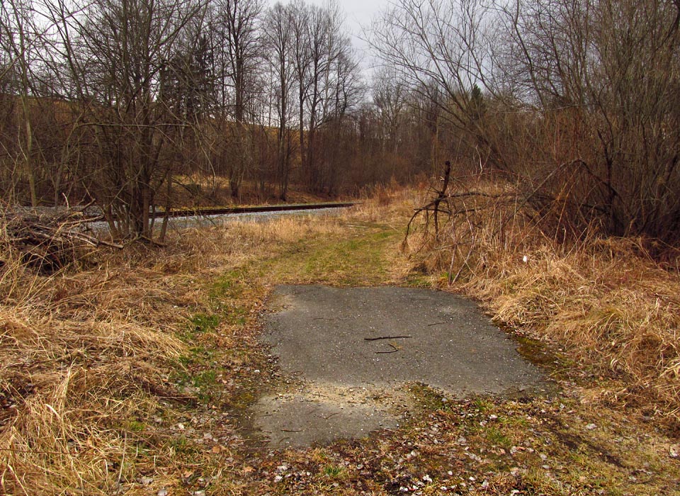 Pozice někdejšího jižního Ondřejovického zhlaví. Na trase bývalé vlečky je zpevněná plocha nesloužící dnes už nikomu a k ničemu.