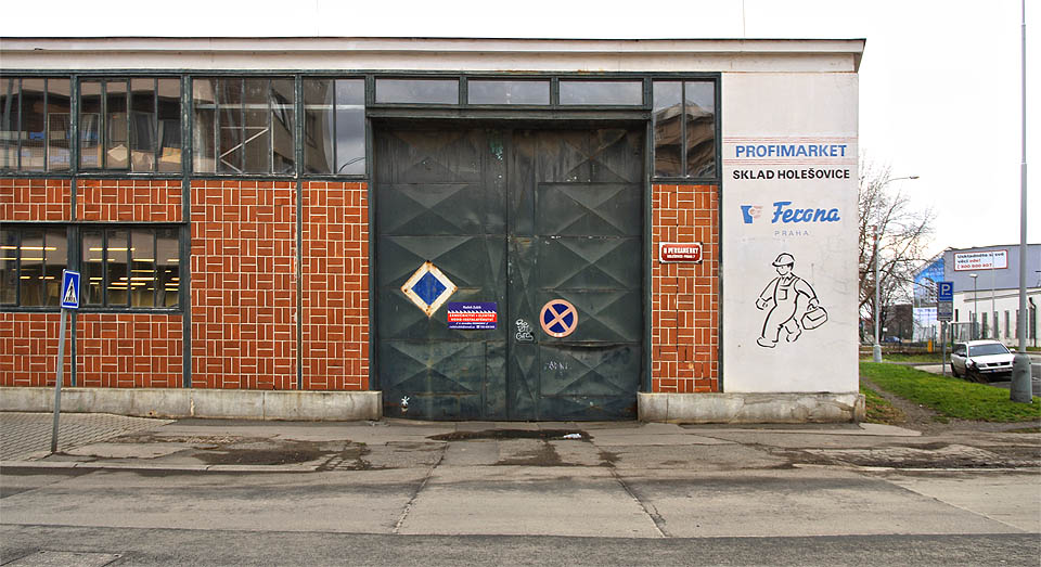 Z koleje <a href=/Tema/Vle%C4%8Dka%20Hole%C5%A1ovick%C3%A1%20p%C5%99%C3%ADstavn%C3%AD%20dr%C3%A1ha%20-%20Ferona>vlečky do Ferony</a> už nezbylo prakticky nic. Na plechových vratech je ale stále vidět modrý čtverec návěsti posun zakázán.