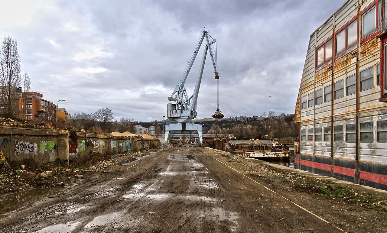 V dolní části přístavu lze pod smutným jeřábem stále nalézt v rozježděném bahně pásy kolejnic, které kdysi propojovaly Holešovice s celým světem. Ne na dlouho, výstavba luxusních bytů brzy dorazí i do míst, kde zatím kotví opuštěné staré lodě. V dolní části přístavu lze pod smutným jeřábem stále nalézt v rozježděném bahně pásy kolejnic, které kdysi propojovaly Holešovice s celým světem. Ne na dlouho, výstavba luxusních bytů brzy dorazí i do míst, kde zatím kotví opuštěné staré lodě.