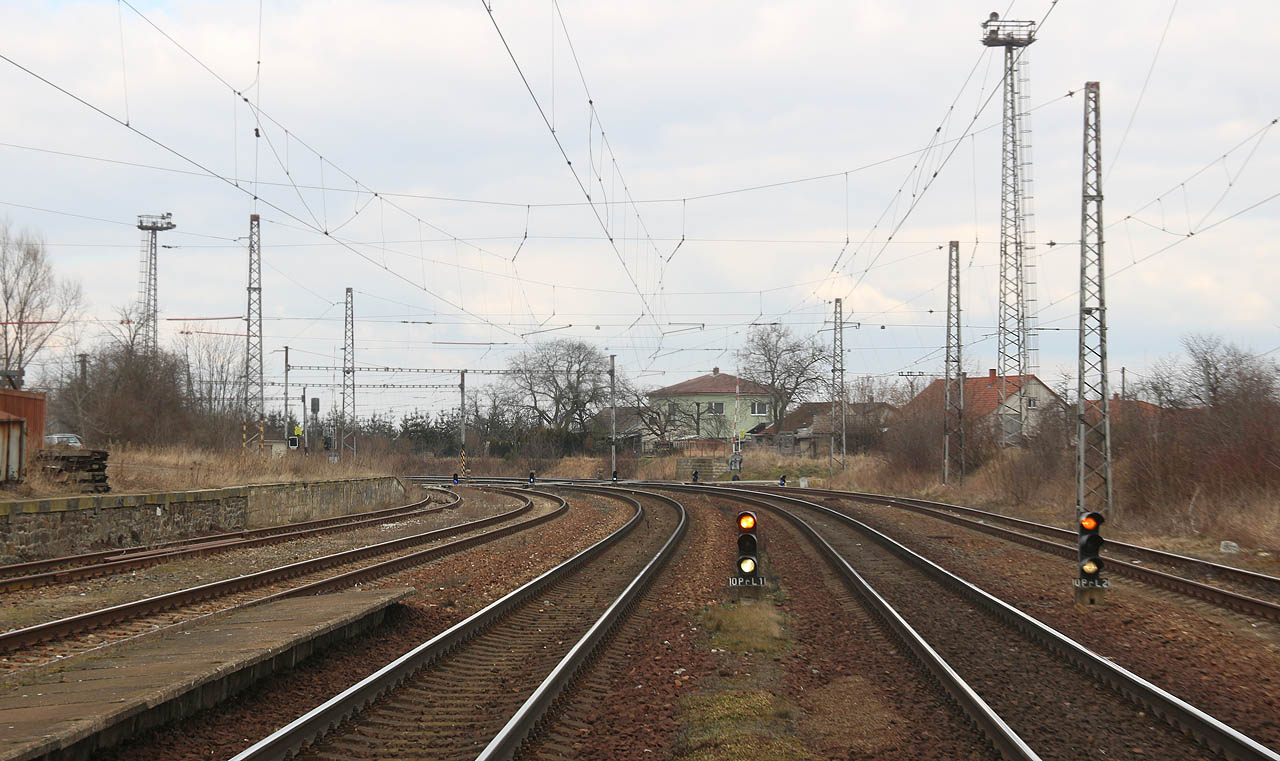 Pohled na sever směrem k Jeníkovskému zhlaví. U dopravních kolejí 1a a 2a září světla opakovacích předvěstí OPř L1 a OPř L2, díky kterým strojvedoucí vidí „až za roh“, tedy za přejezd P3702, kde se nachází hlavní odjezdová návěstidla L1 a L2.