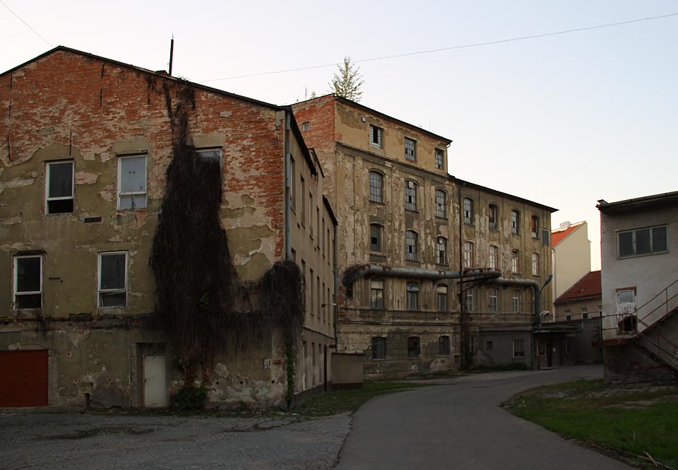 Vlněně ale není přáno. Rozmanité budovy různých tvarů, barev a výšky, nepravielné bloky a místa přímo křičící historií zaniknou a uvolní místo sériovým budovám jen o málo lepším než paneláková sídliště na periferii.
