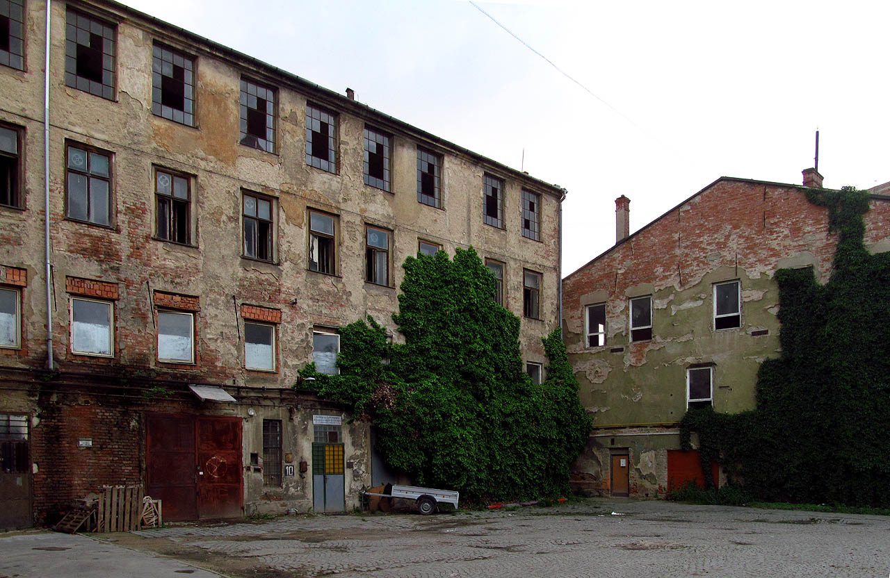 Zvláštní období mezi roky 2000 a 2016 bylo čímci mezi životem a smrtí Vlněny. Z rozbitých oken padaly kusy skla na chodce mířící do loftových bytů, zkušeben kapel obskurních hudebních žánrů, živořících firem na hraně zákona a bůh ví, řeho ještě.