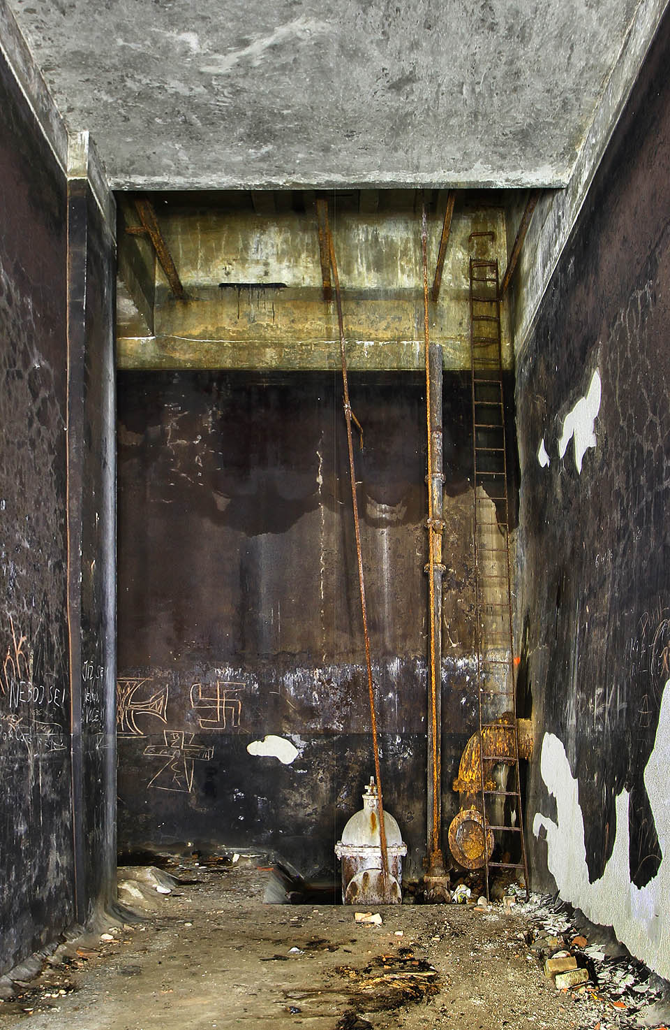 Detailní pohled na vstupní šachtu nového vodojemu s šoupětem a armaturou vedoucí do šoupátkové komory. Výzdoba na stěnách je výmluvná.