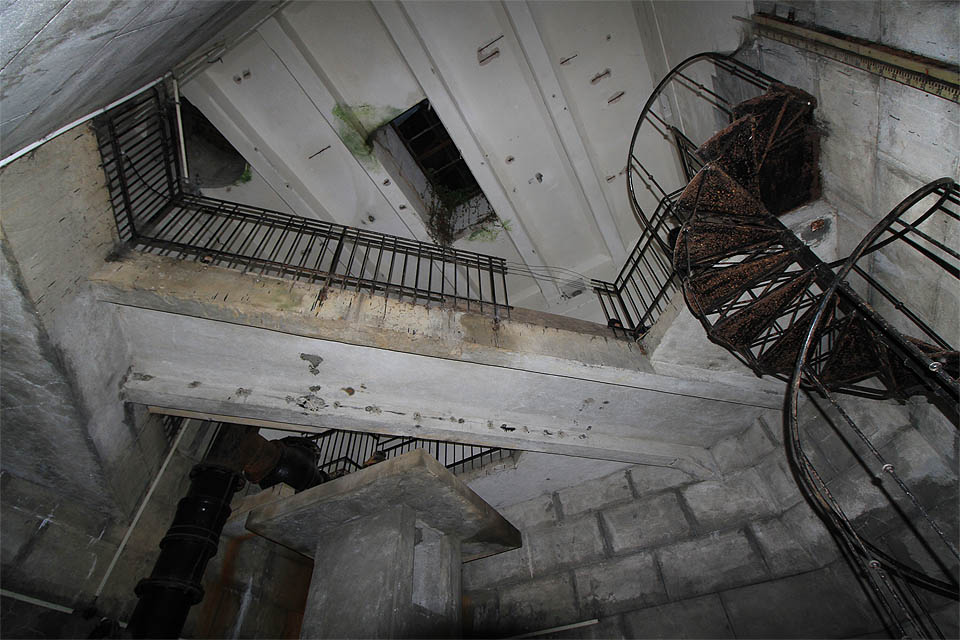 Pohled vzhůru ze dna armaturní komory, ke světlíku, kterým pomalu do kdysi sterilních vodojemů proniká příroda.