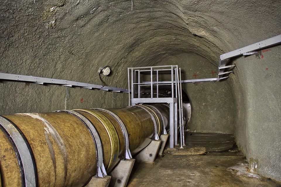 Za skromnou přechodovou lávkou se potrubí vrací do třímetrové betonové štoly, kterou pokračuje další tři kilometry.