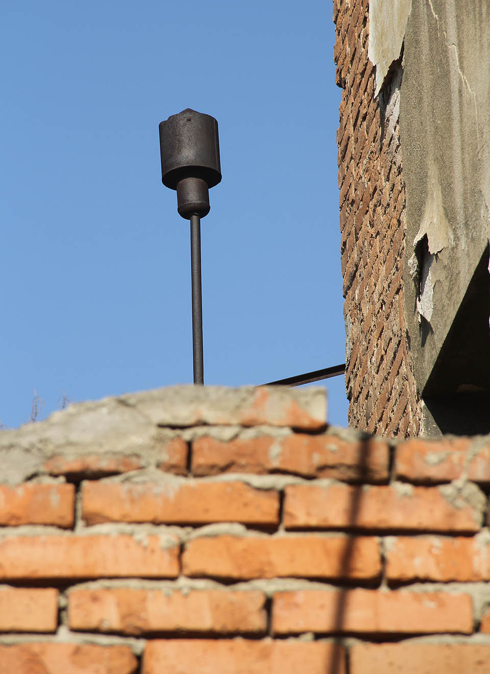 Z vnější strany fasády je připevněno cosi, co vypadá jako přetlakový ventil - že by poslední památka na parní stroj, který byl kdysi srdcem továrny?