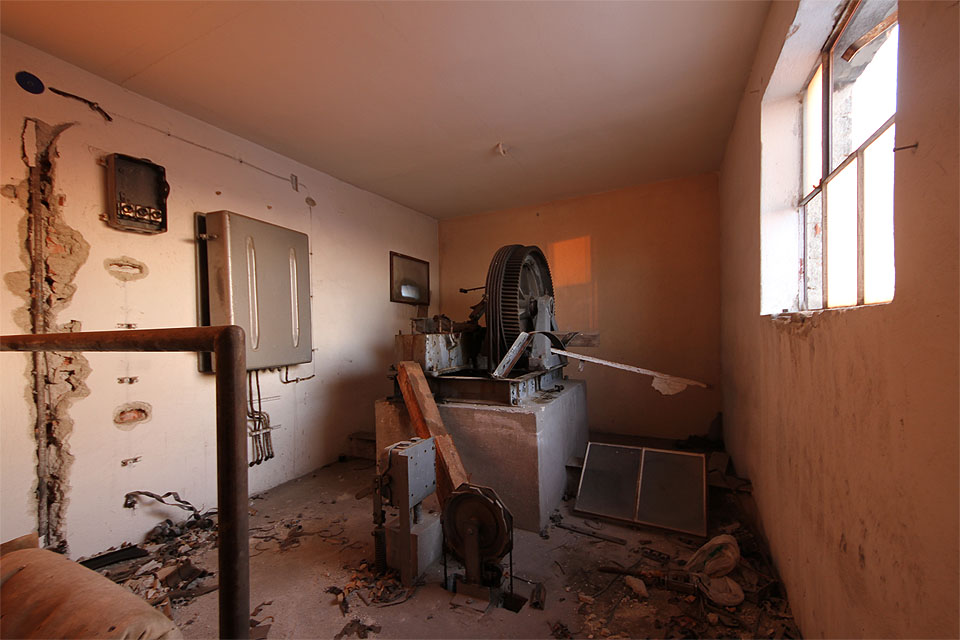 Nad kovovými schůdky se ukrývá strojovna beznadějně zastaveného výtahu.